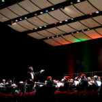 orchestra on stage wearing santa hats