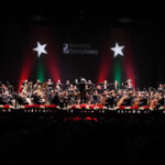 symphony orchestra on stage with holiday decorations